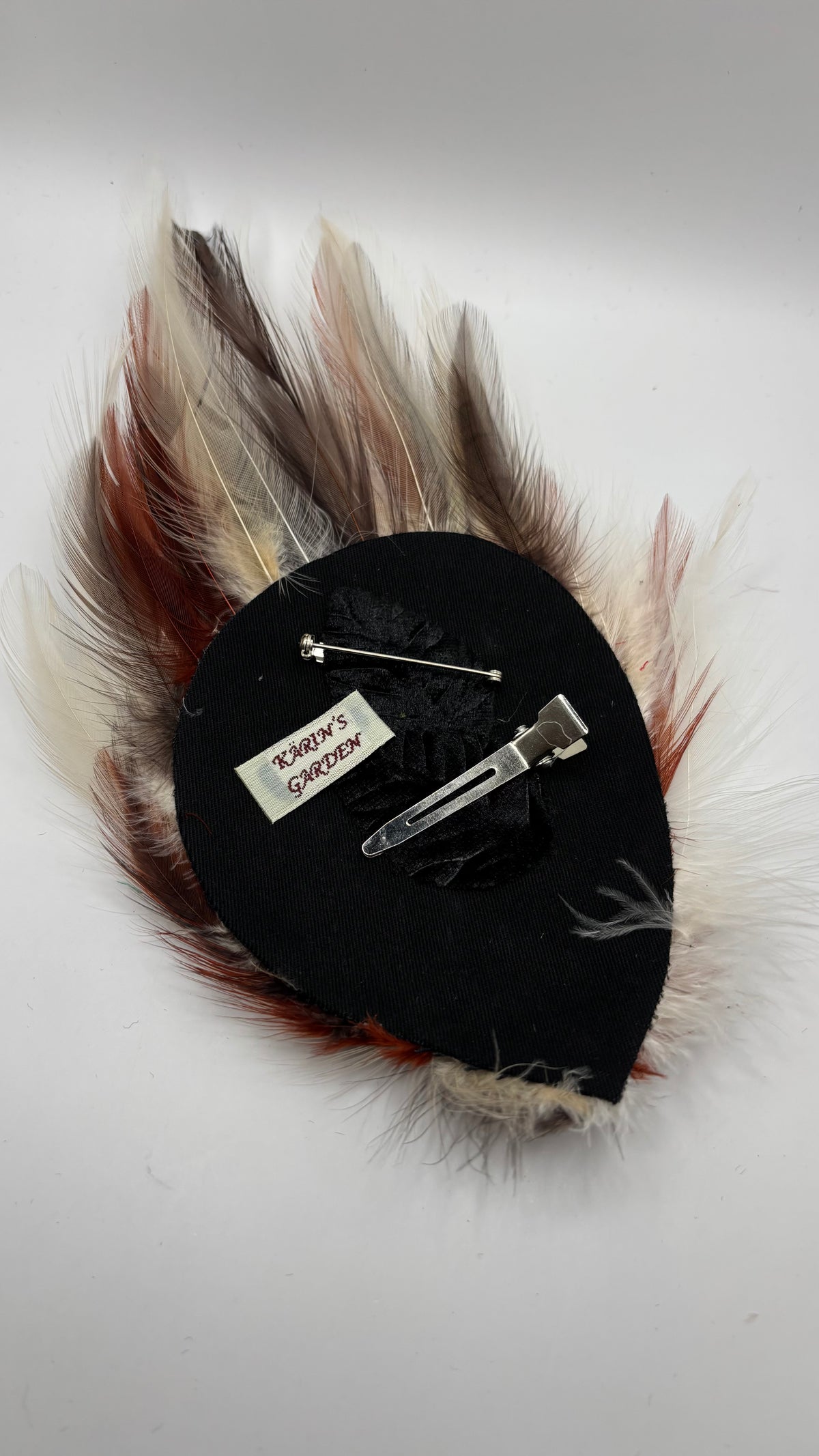 Back of Garbo Brick, Brown & Ivory feather pin showing bar pin, pinch clip and label