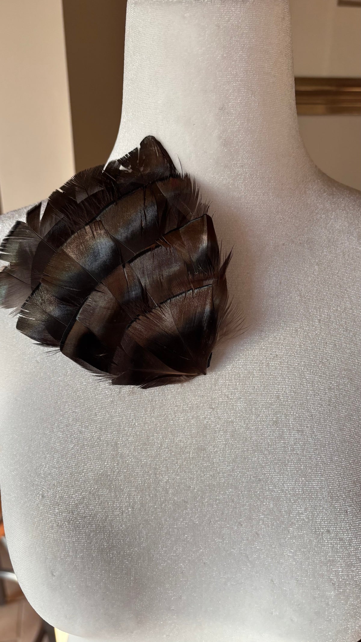 Garbo Iridescent Bronze & Black feather pin and clip close-up on dress form