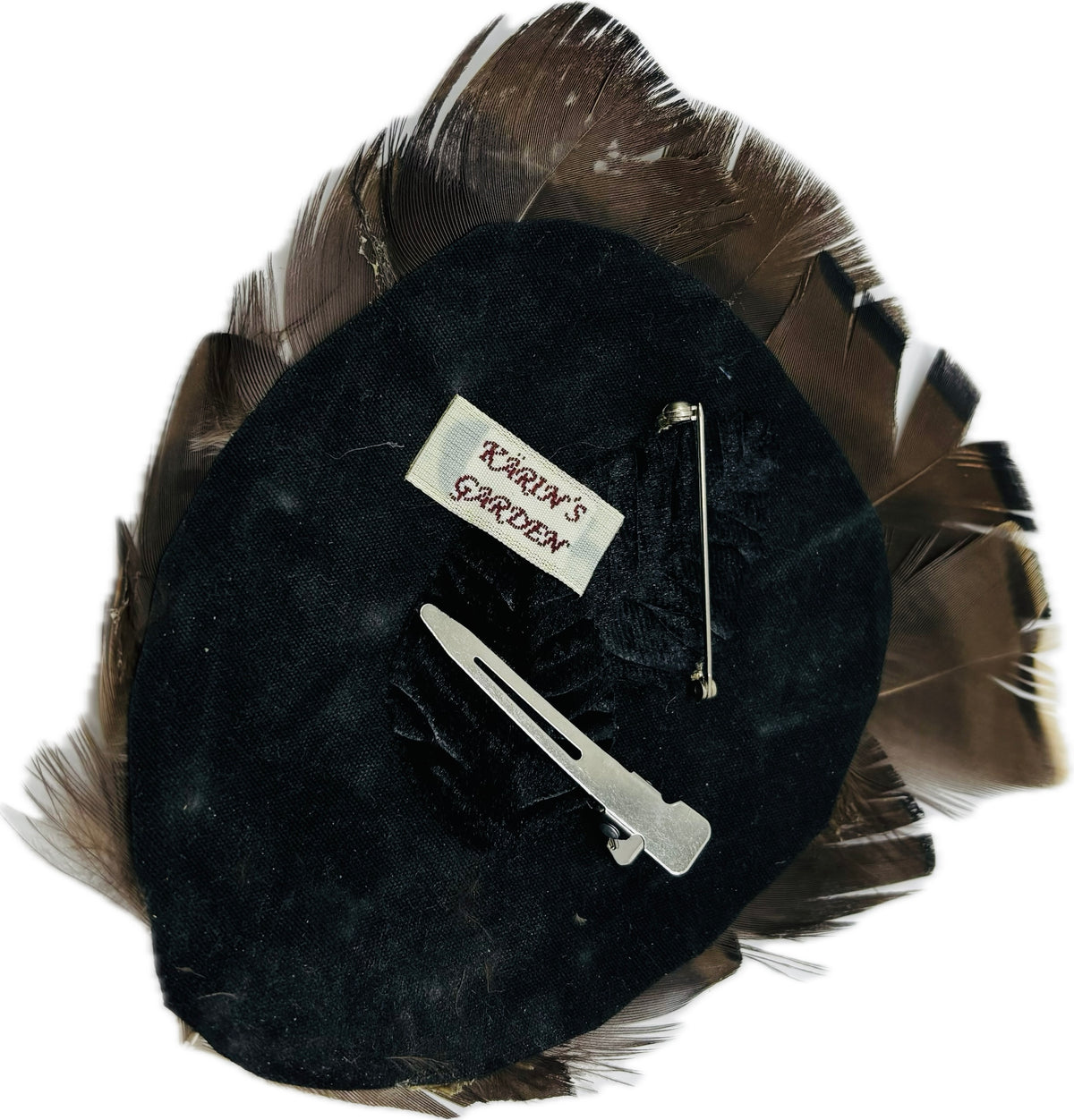 Back of Garbo Iridescent Bronze & Black feather pin showing black velvet leaves, bar pin, pinch clip and label
