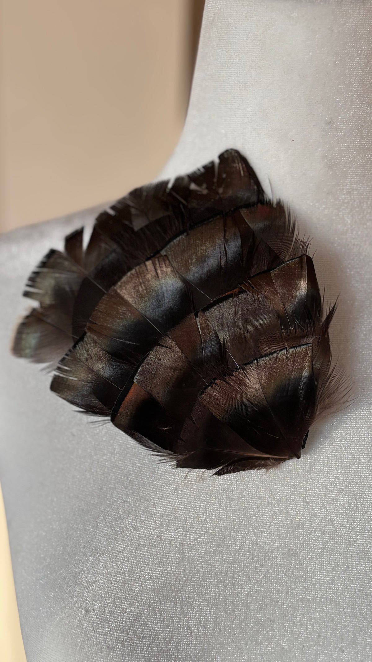Garbo Iridescent Bronze & Black feather pin and clip pinned on dress form